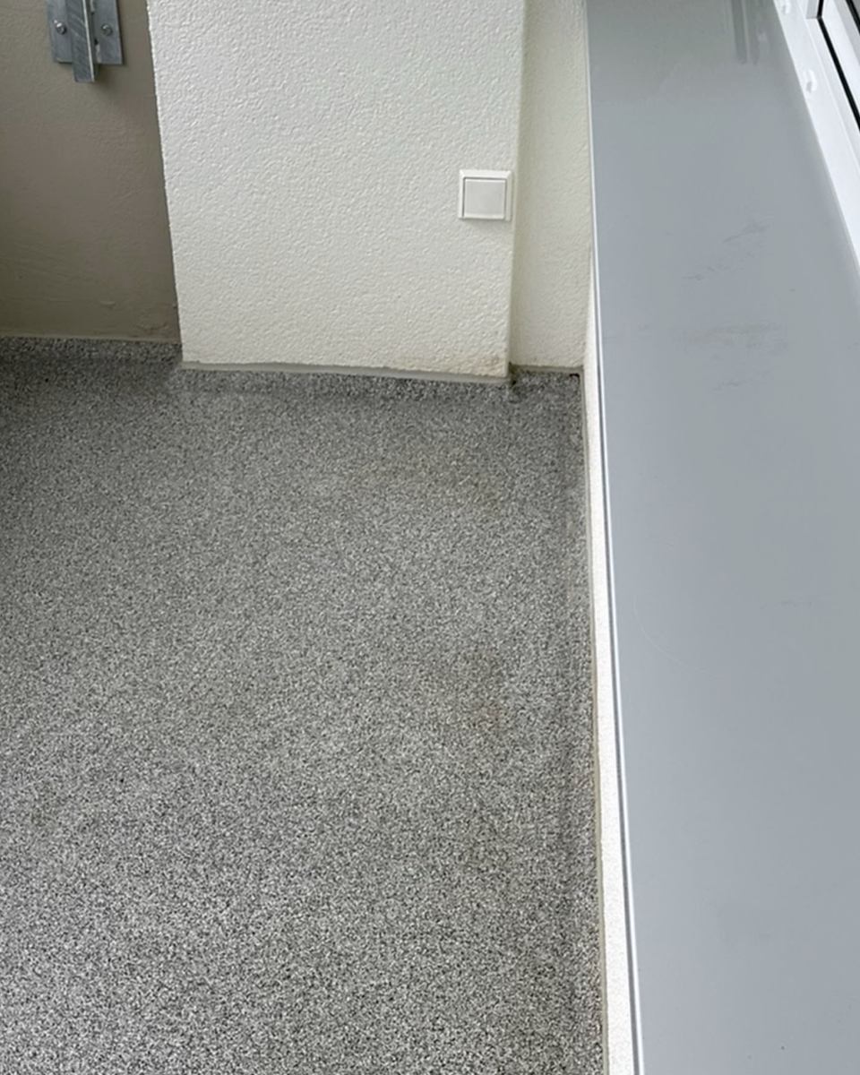 Nachher: Balkonecke mit Steinteppich, vorher mit Laub, Rinde und Sand bedeckt, nachher sauber.