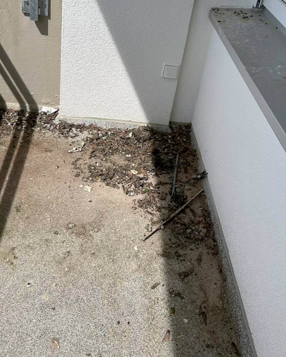 Vorher: Balkonecke mit Steinteppich, vorher mit Laub, Rinde und Sand bedeckt, nachher sauber.