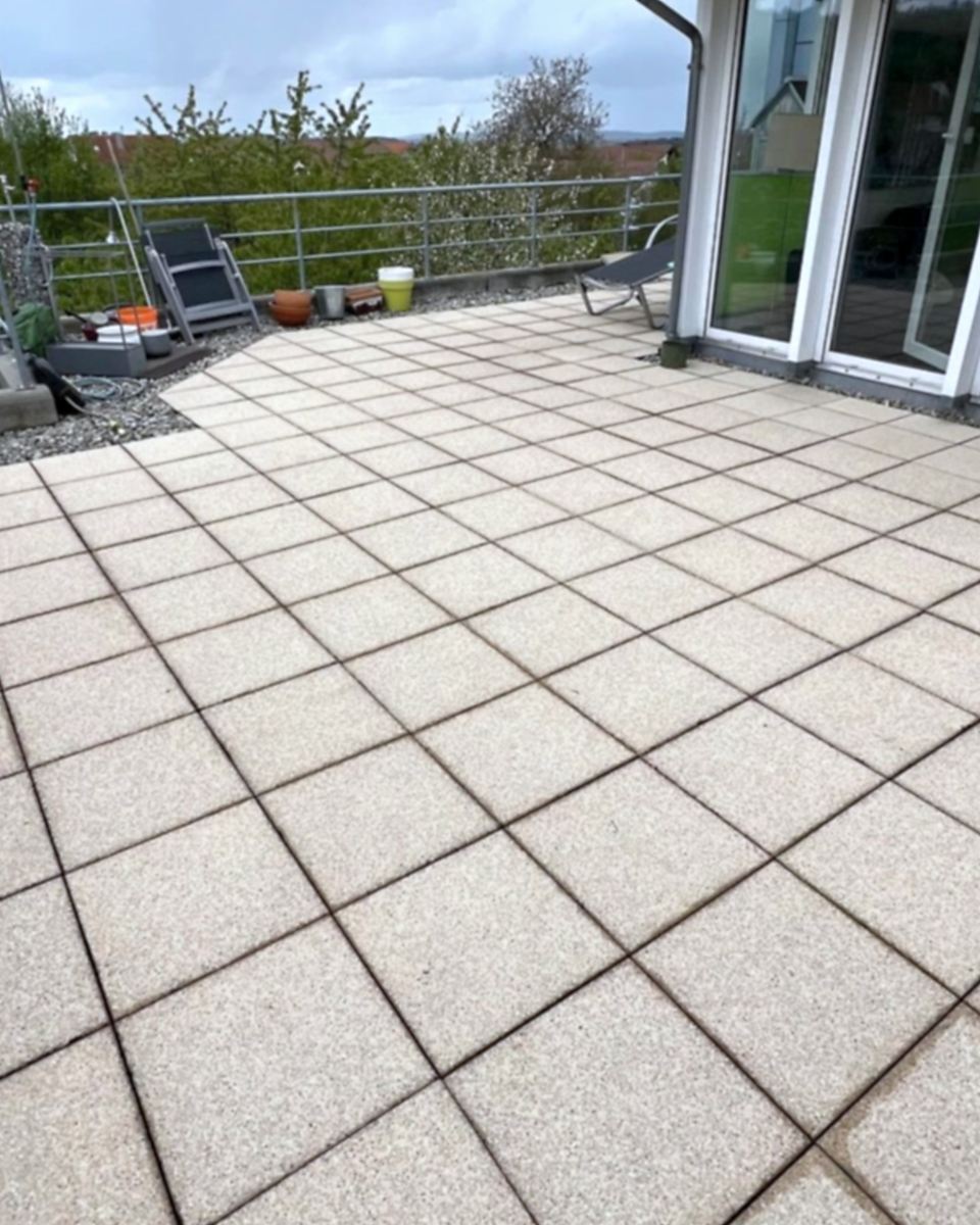 Nachher: Terrasse mit Betonplatten, vor der Reinigung vergraut und fleckig, danach hell und sauber.